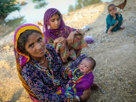 Uma mãe de quatro filhos sentada perto da água da enchente, depois de fugir da enchente, chegou em casa. Ela e a sua família refugiaram-se à beira da estrada no distrito de Jacobabad, província de Sindh, Paquistão. UNICEF/Zaidi