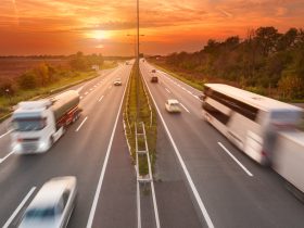 Foto panorâmica do tráfego de uma rodovia com ônibus e caminhões