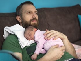 Pai cuidando da filha recém-nascida