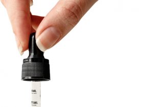 Pessoa segurando conta-gotas com extrato de cannabis