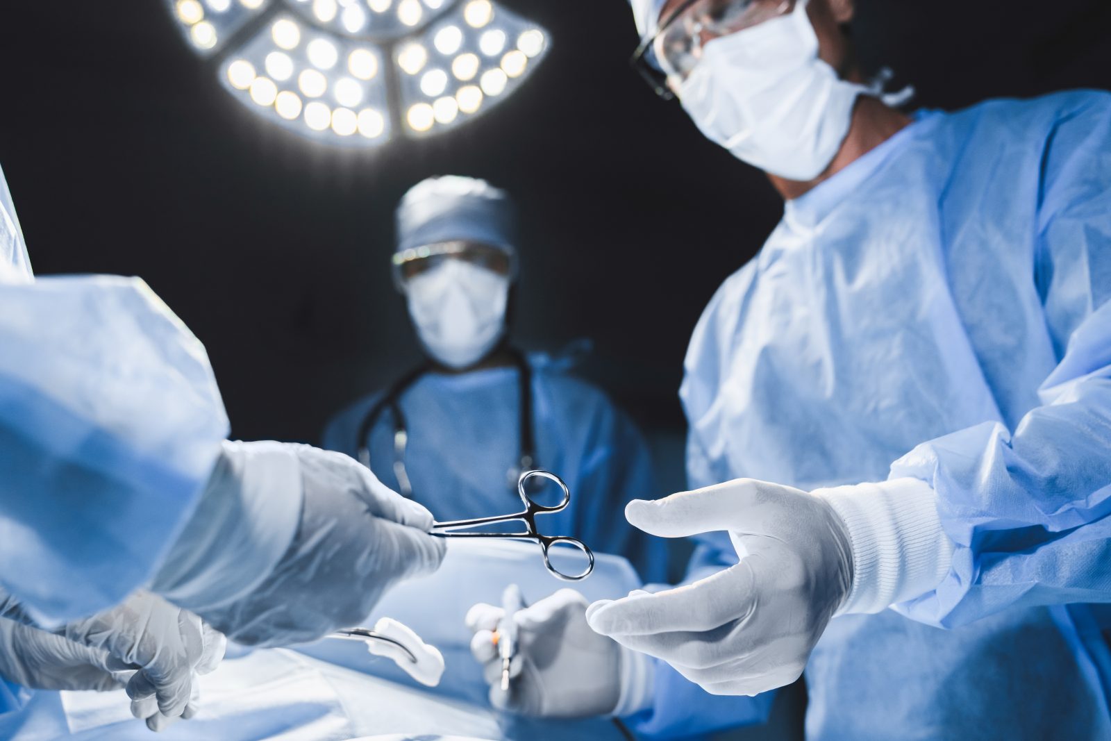 Close-up da equipe de cirurgia operando em um hospital moderno. Por insidecreativehouse