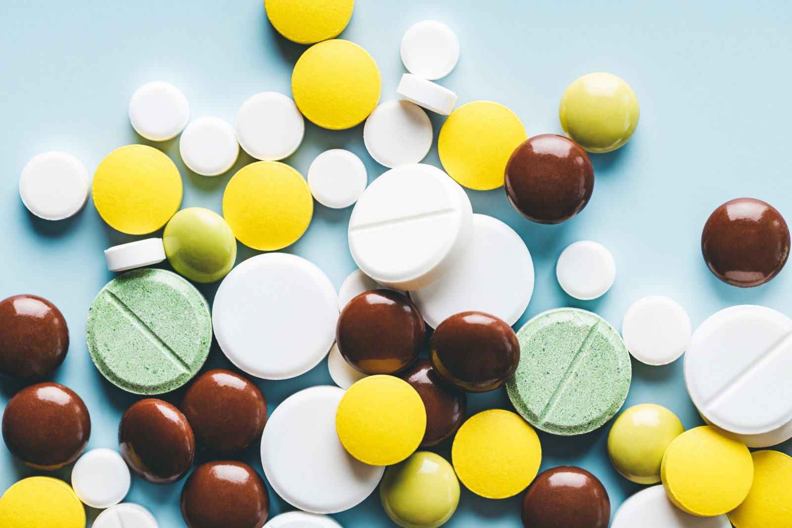 Várias pílulas em fundo azul. Por fucsiya