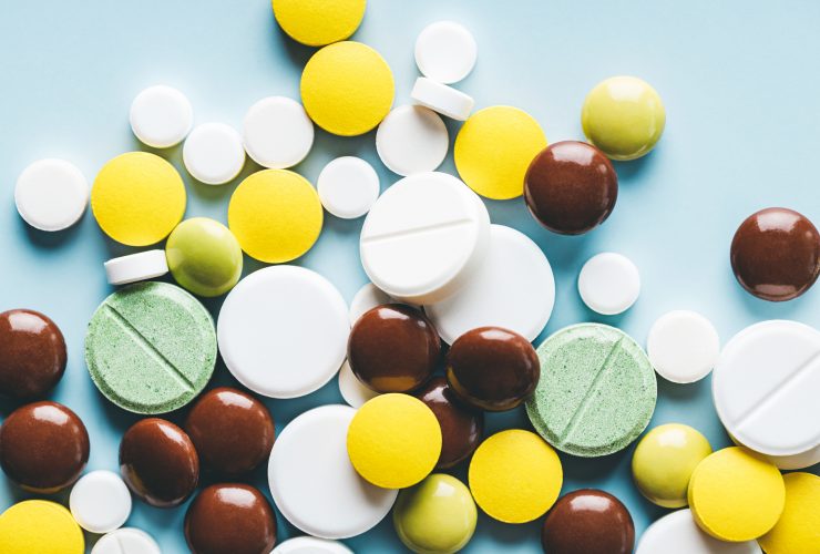 Várias pílulas em fundo azul. Por fucsiya