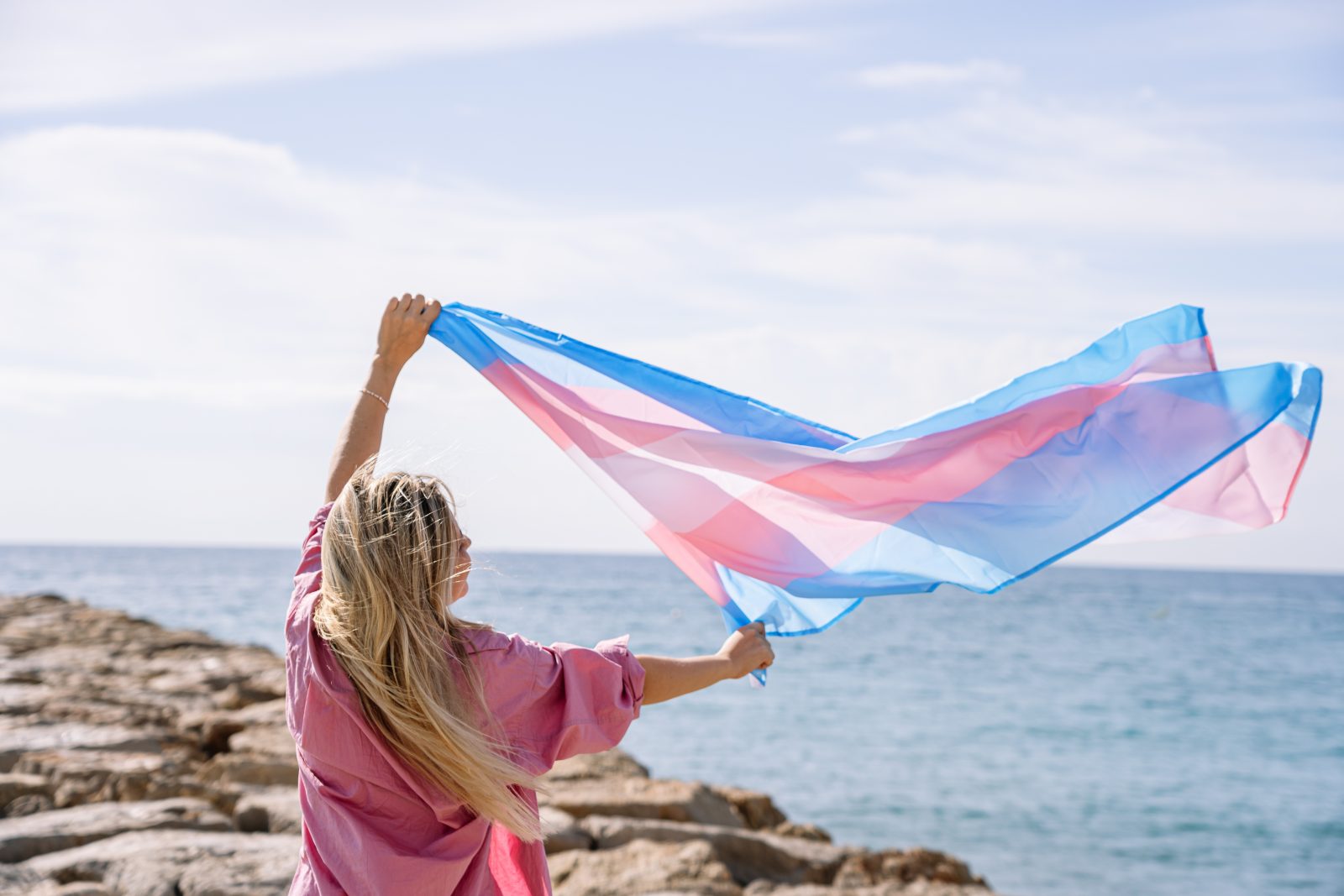 Jovem mulher com bandeira trans Por guillemd