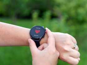 Foto de close-up da pessoa monitorando a frequência cardíaca no relógio inteligente ao ar livre Por anelehbakota