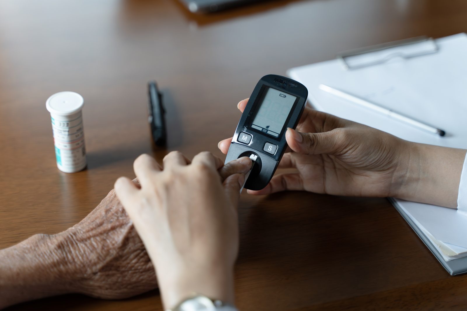 Diabetes, enfermeira. Profissional de saúde, saúde e médico com medidor de glicose para testar o nível de insulina Por Kenstocker