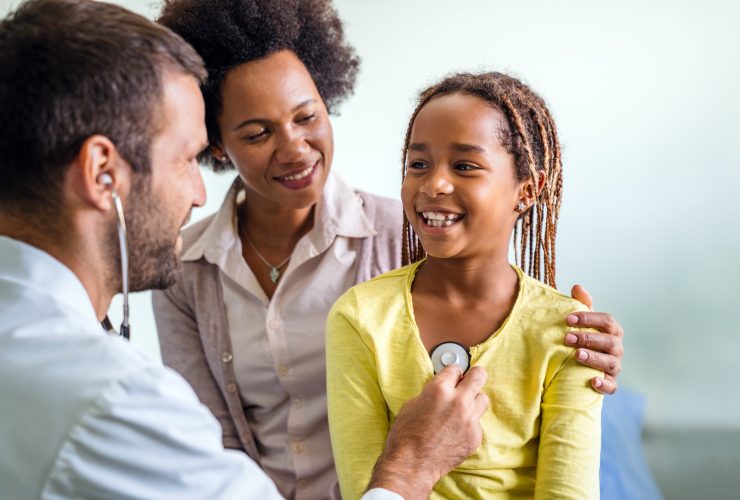 Conceito infantil de pessoas de exame médico de saúde. Close-up de menina feliz e médico com estetoscópio Por nd3000
