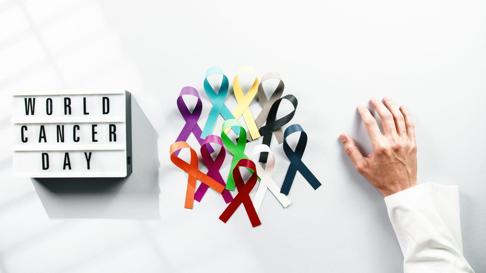 fita do dia mundial de conscientização do câncer com a mão de um médico Por PolonioVideo