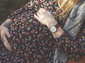 Close-up da barriga da mulher grávida Por westend61