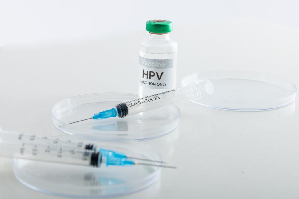 Composição do frasco e seringas da vacina contra o HPV em fundo branco com espaço de cópia Por Wavebreakmedia