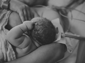 Menina recém-nascida amamentando após o nascimento Por laceybeth