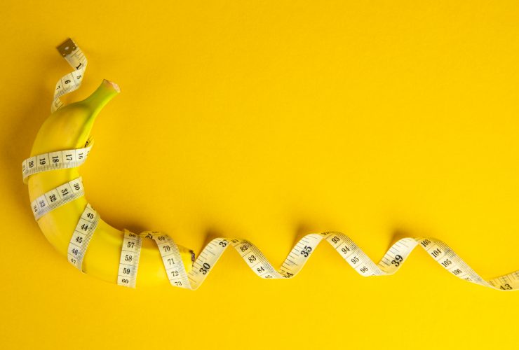 Banana e fita métrica em fundo amarelo. Conceito de dieta. Por tehcheesiong