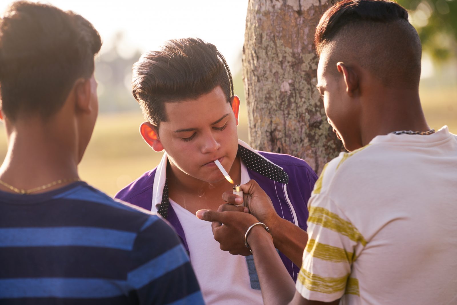 Grupo de adolescentes fumando cigarro com amigos Por diego_cervo