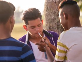 Grupo de adolescentes fumando cigarro com amigos Por diego_cervo
