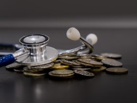 Economia de dinheiro, conceito financeiro. moedas e estetoscópio em fundo preto Por yavdat