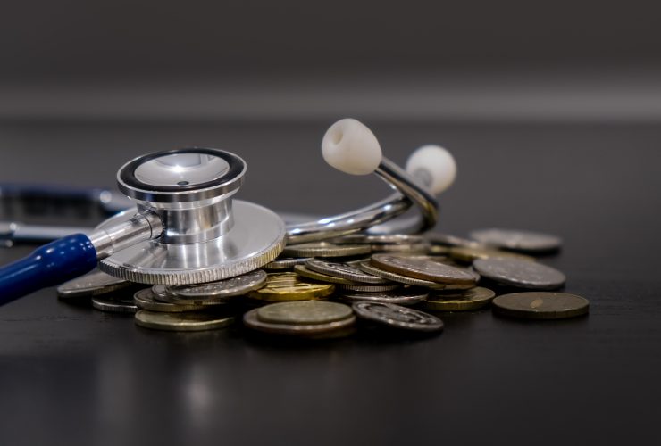 Economia de dinheiro, conceito financeiro. moedas e estetoscópio em fundo preto Por yavdat