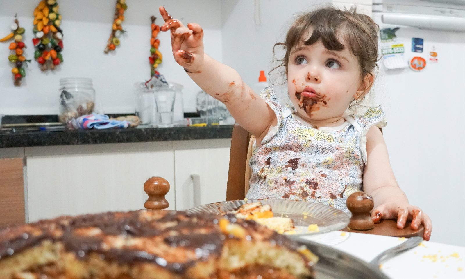 Criança comendo bolo de chocolate Por msandrioli