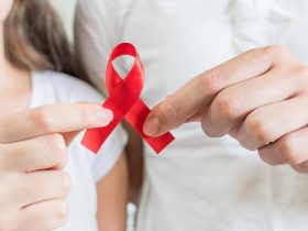 A fita vermelha é o símbolo universal de conscientização e apoio às pessoas que vivem com HIV Por wirestock