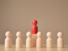 Figura de boneca de madeira vermelha em pé na frente da multidão Por innu_asha84