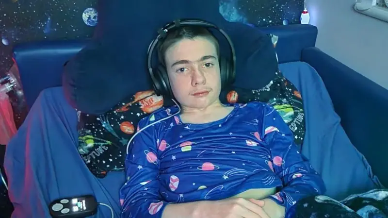 Oran Knowlson, de treze anos, sendo o primeiro paciente do teste com o dispositivo Foto: Justine Knowlson