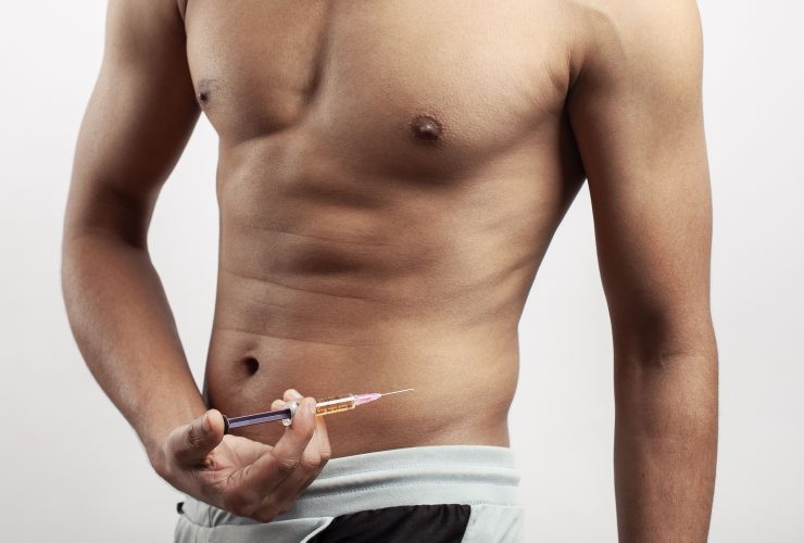 homem injetando hormônio testosterona em seu corpo Por wirestock