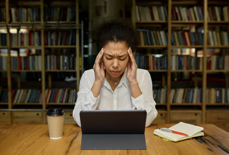 Trabalhador de escritório tocando a cabeça massageando as têmporas que sofrem de dor de cabeça ou tensão Por NomadSoul1