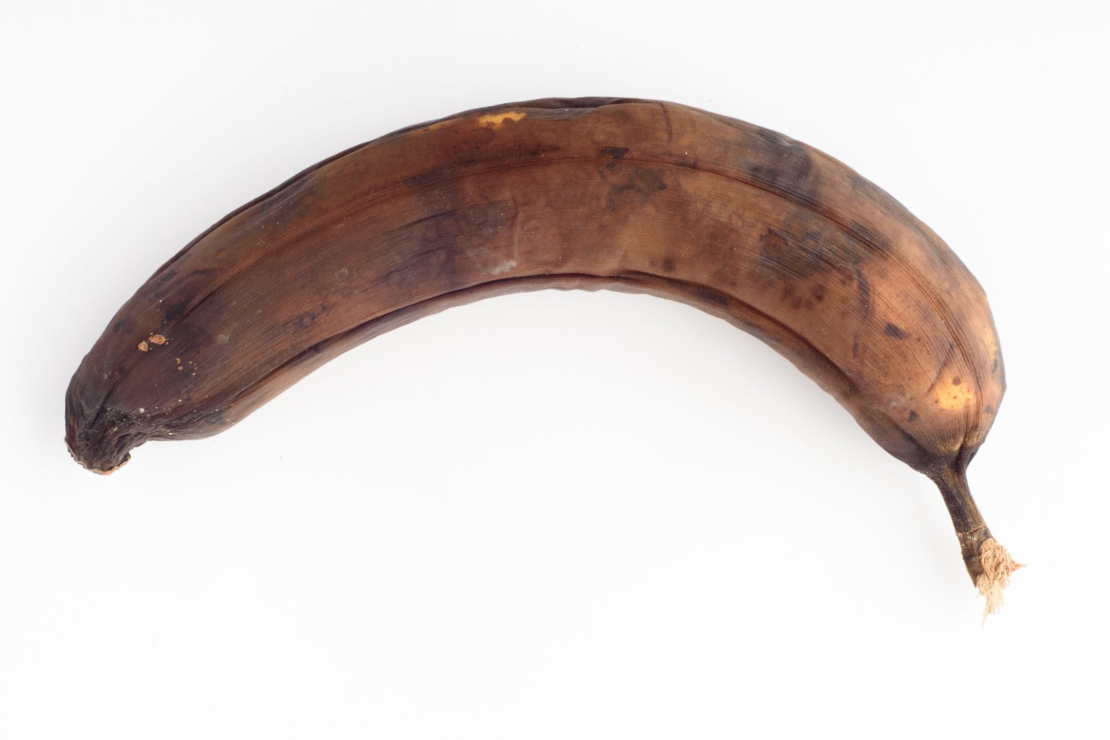 Banana podre isolada no fundo branco. Por wolfhound9111