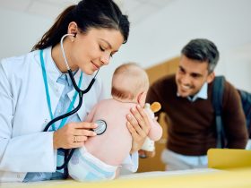 Pediatra do sexo feminino e bebê durante exame médico no consultório médico. Por drazenphoto
