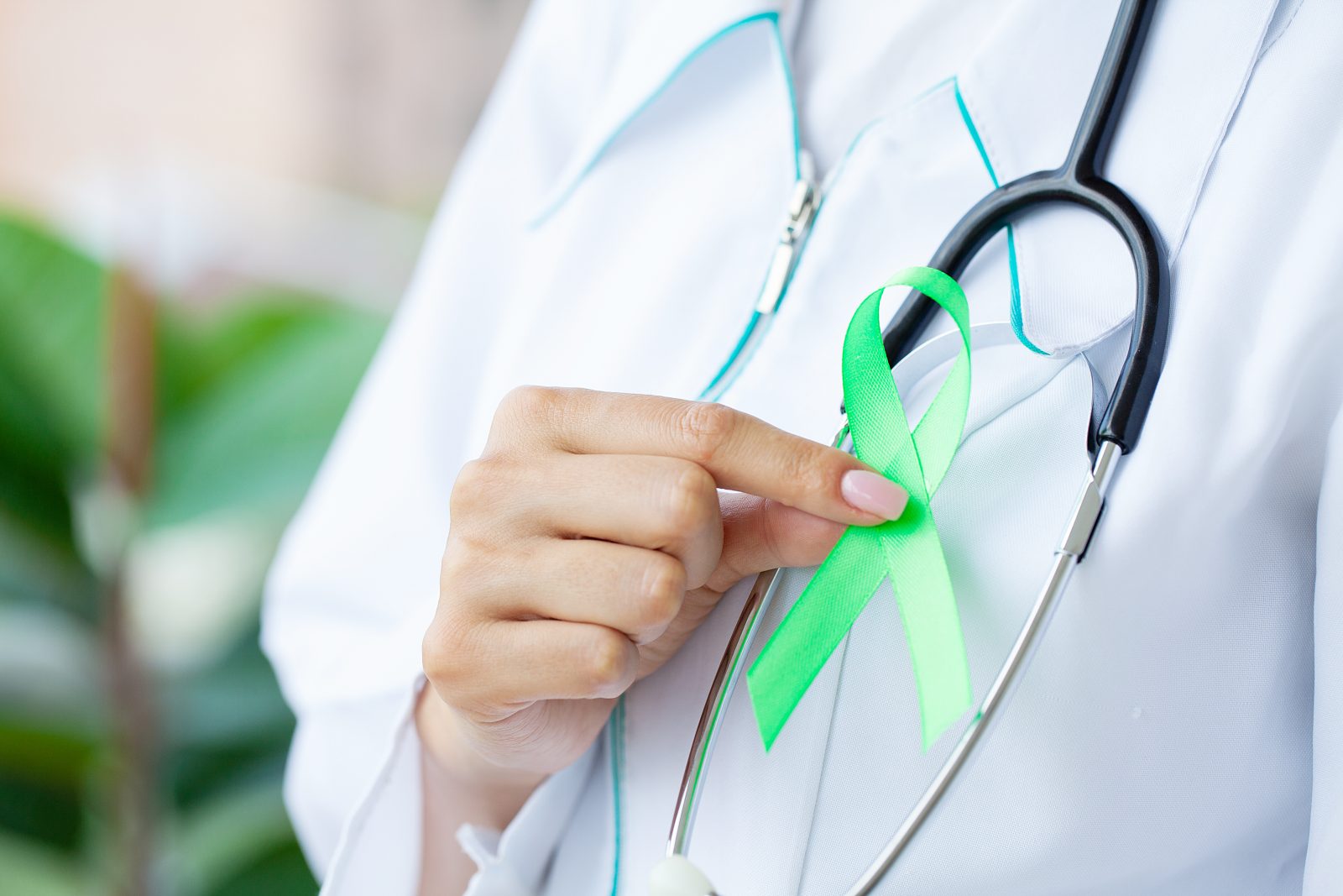 Fita verde na mão como símbolo de conscientização Câncer de linfoma Por maksymiv