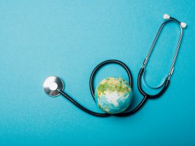 Vista superior do globo e estetoscópio em fundo azul, conceito do Dia Mundial da Saúde Por LightFieldStudios
