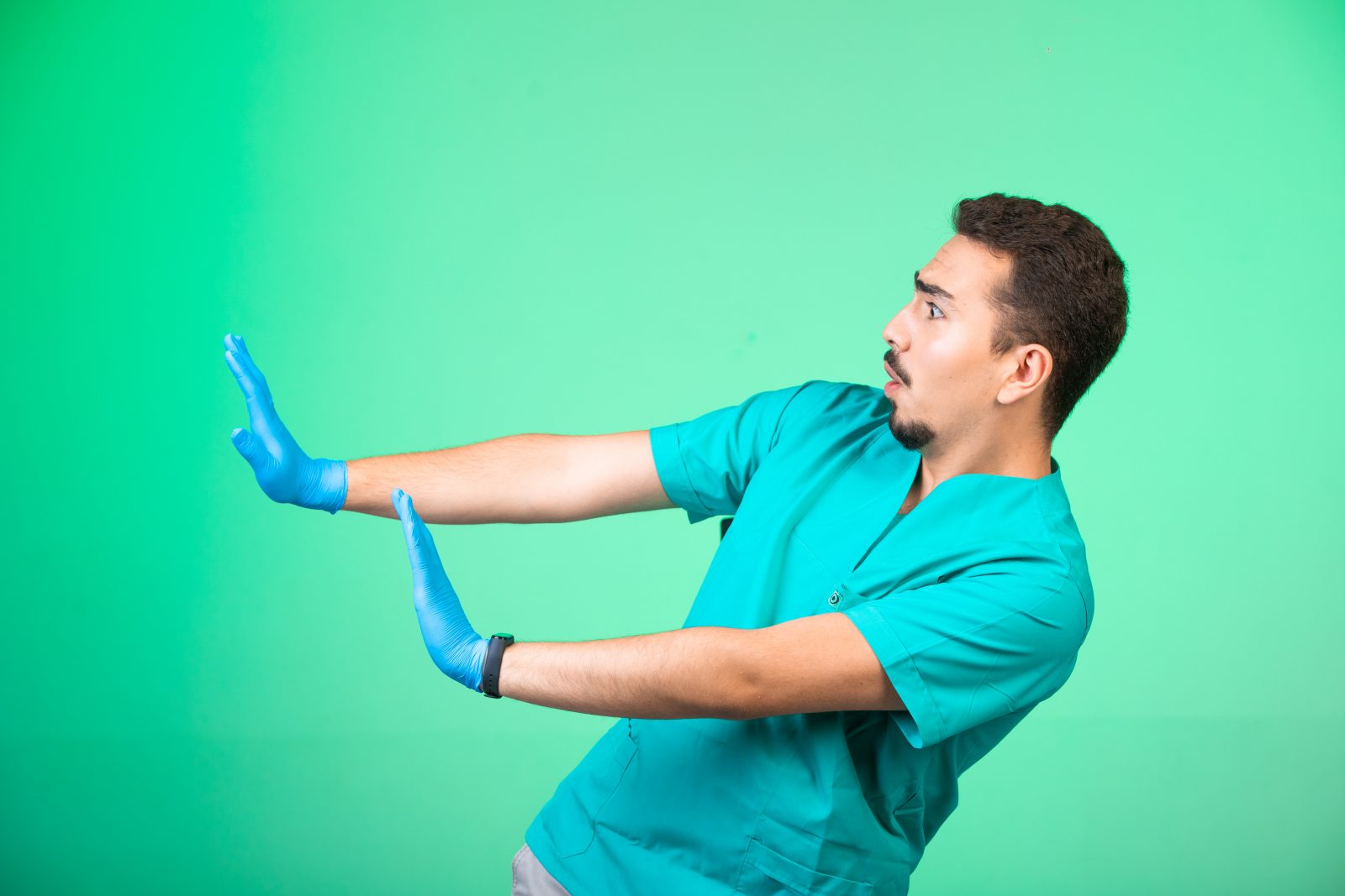 Médico de uniforme e máscara de mão se prevenindo Por 13people