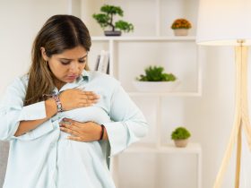 Mulher tocando seu seio examinando o câncer de mama Por GSR-PhotoStudio