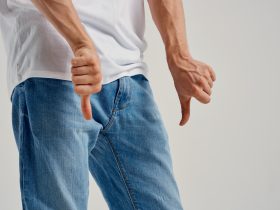 homem mostrando gesto negativo com problemas nas mãos com os órgãos genitais Por shotprime