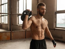 Homem sem camisa malhando com kettlebell Por kegfire