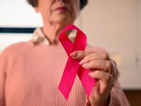 Idosa idosa doente, aposentada, aposentada, mulher madura, segura fita vermelha, conscientização sobre HIV e AIDS Por jm_video