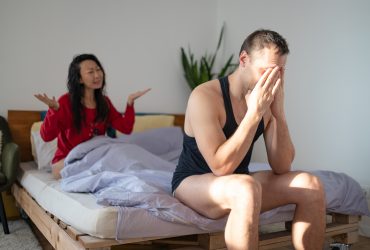 homem deprimido sentado na cama com a namorada após uma briga, conceito de problemas sexuais. Por nikolast1