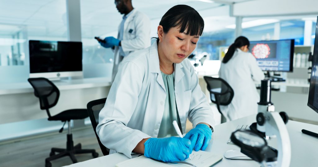 Cientista, mulher e escrevendo notas em laboratório com pesquisa médica, planejamento e solução na farmácia Por YuriArcursPeopleimages