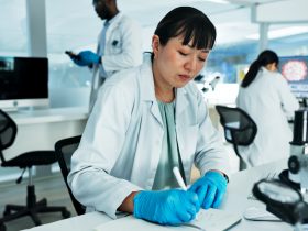 Cientista, mulher e escrevendo notas em laboratório com pesquisa médica, planejamento e solução na farmácia Por YuriArcursPeopleimages