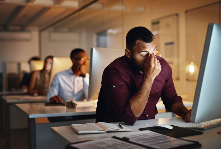 Foto de um jovem empresário parecendo estressado enquanto trabalhava até tarde em um escritório Por YuriArcursPeopleimages
