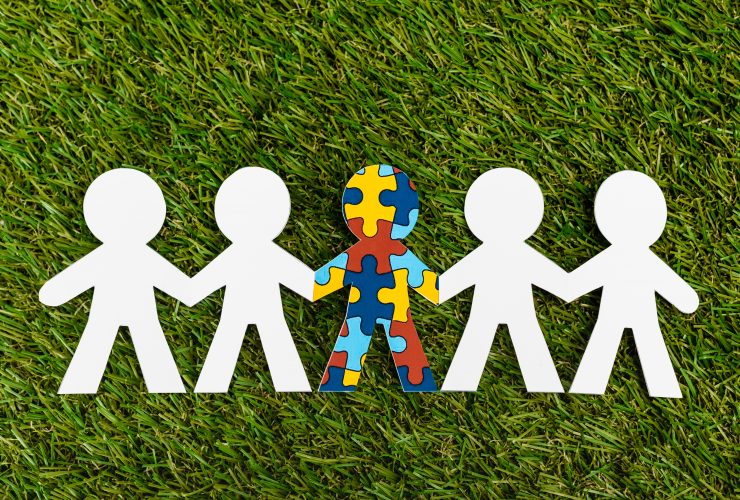 Vista superior do garoto especial com autismo entre outro em fundo verde Por LightFieldStudios